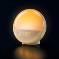 Sunrise wake-up light alarm clock glowing amber against a dark background